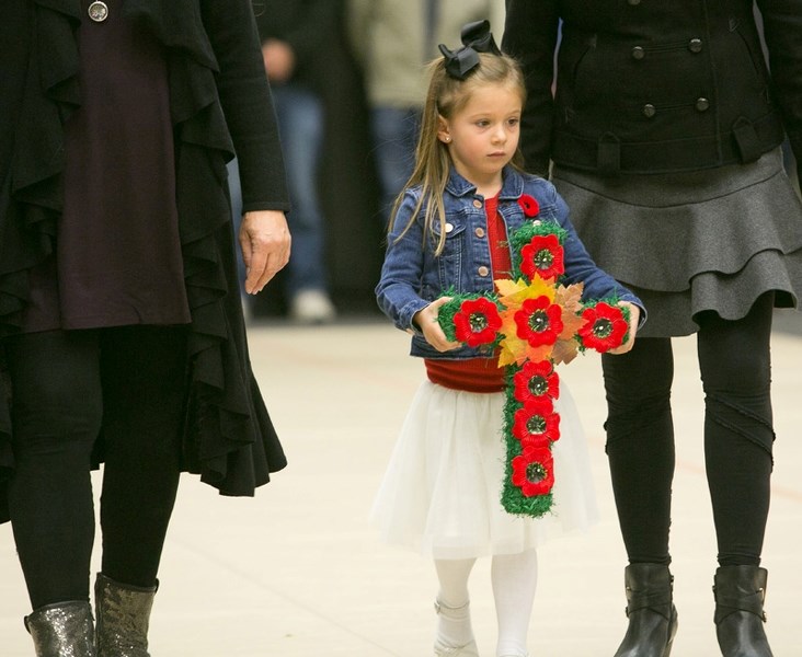 Brooklyn Overwater brings a wreath to lay at the cenotaph during Remembrance Day ceremonies in Olds on Friday.
