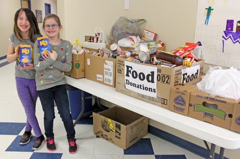Olds Koininia Christian School students Nataliea Beaver-Hawman, left, and Melody Fuller organized a food drive which ended last Thursday (March 23) with six boxes of goods