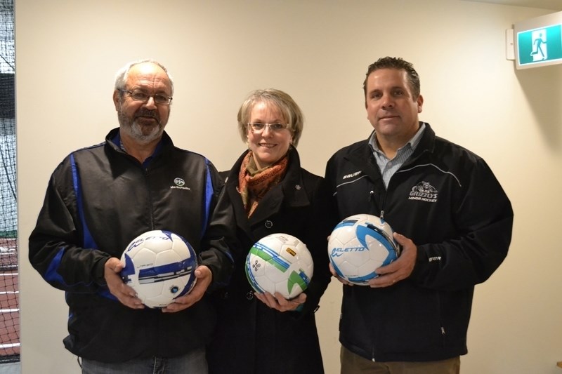 From left, Brian Johnson, Addy Johnson and Digger Sports owner Darcy Cruickshanks display some of the soccer balls Digger Sports donated to teams in Honduras.