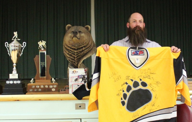 Grizzlys head coach Dana Lattery holds up a retro team jersey being auctioned off during the team&#8217;s annual awards banquet, held last Friday (April 21) at the Evergreen