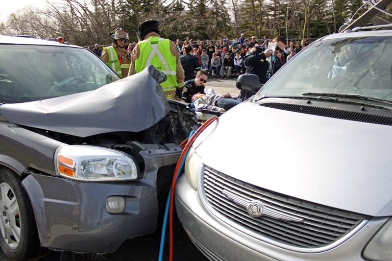 CRASH SCENE &#8211; An ambulance worker deals with an accident victim played by Olds High School student Isabelle Layden during a mock drunk driving accident last Wednesday