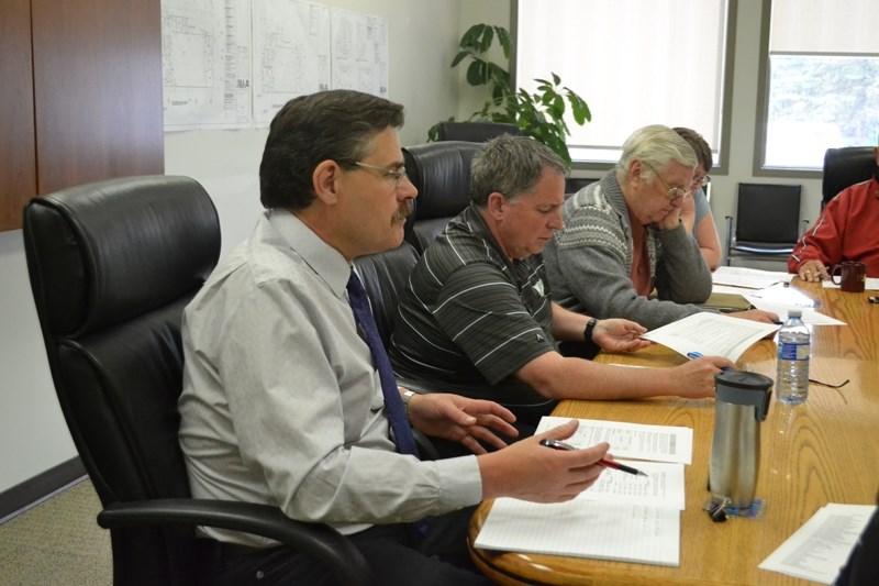 Bowden chief administrative officer James Mason, foreground, responds to a suggestion by Coun. Paul Webb (in striped T-shirt) that the town increase taxes in smaller amounts