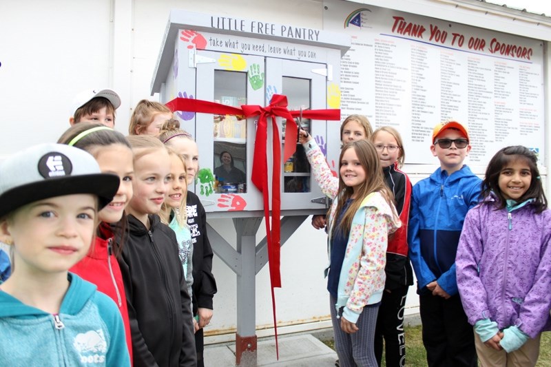 Members of the Ècole Olds Elementary School&#8217;s Care Club were on hand for the grand opening of their Little Free Pantry in Centennial Park. Rowan Lansing cut the ribbon, 