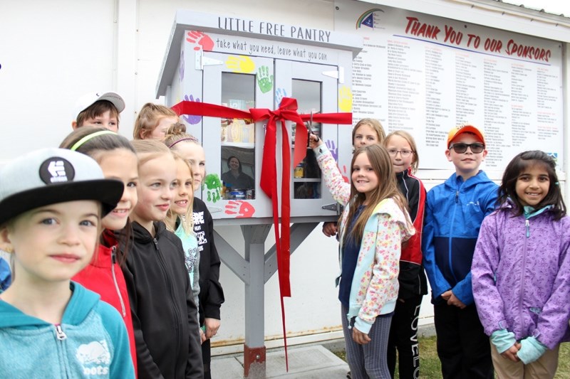 Members of the Ècole Olds Elementary School&#8217;s Care Club were on hand for the grand opening of their Little Free Pantry in Centennial Park. Rowan Lansing cut the ribbon, 
