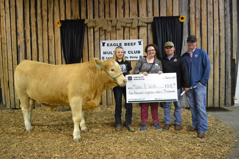 Dreamer, a donation steer raised by Eagle Beef and Multi 4-H Club president Annelise Corbett, 15, left, was bought by Shell Canada&#8217;s Caroline plant for $5,018 and