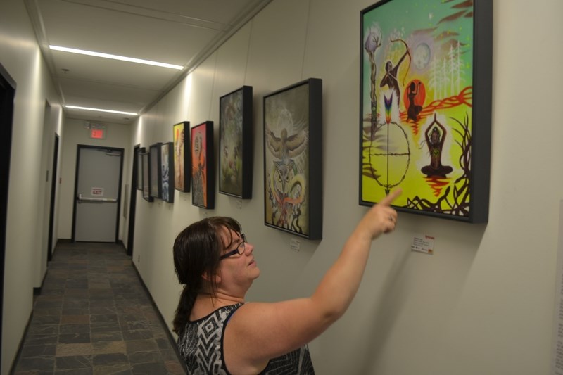 Olds Municipal Library manager Lesley Sackett Winfield points out some of the things she likes best about an exhibition of aboriginal art, now on display in the library.