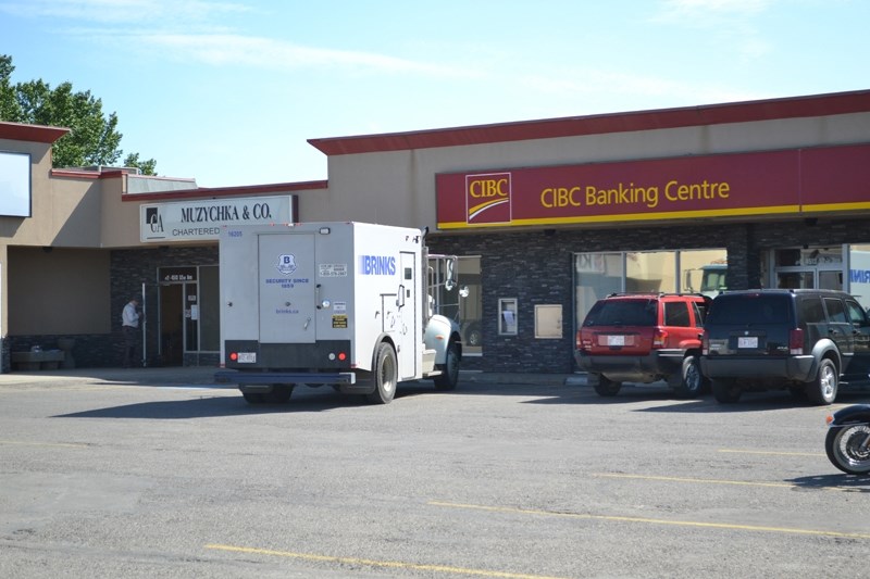 A worker repairs the front door of Muzychka &#038; Co. Chartered Accountants after thieves broke into that business to steal money from the adjacent CIBC in Olds on July 3.