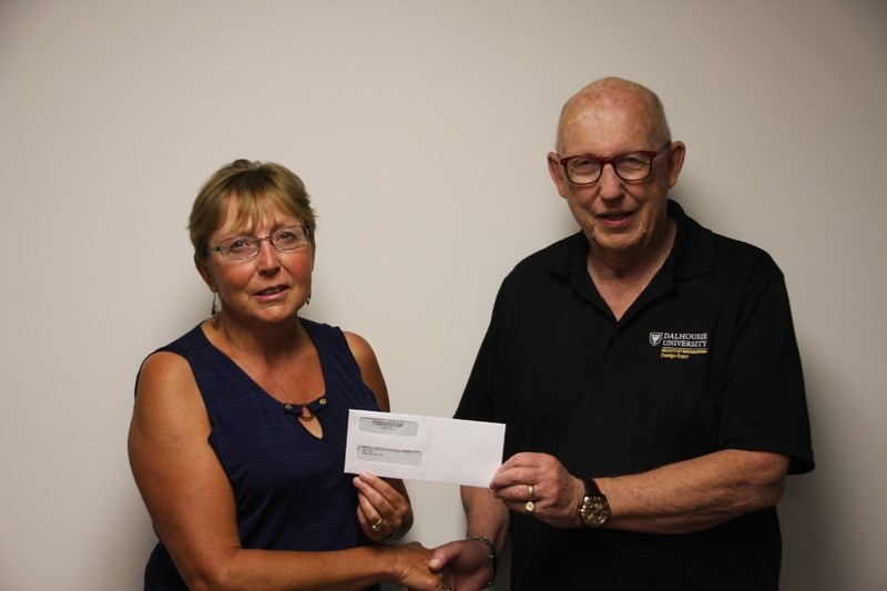 Bill Johnston of the Kiwanis Club of Olds presents Roberta Hammer, president of the Mountain View Emergency Shelter Society with a cheque for $10,000 to go towards its