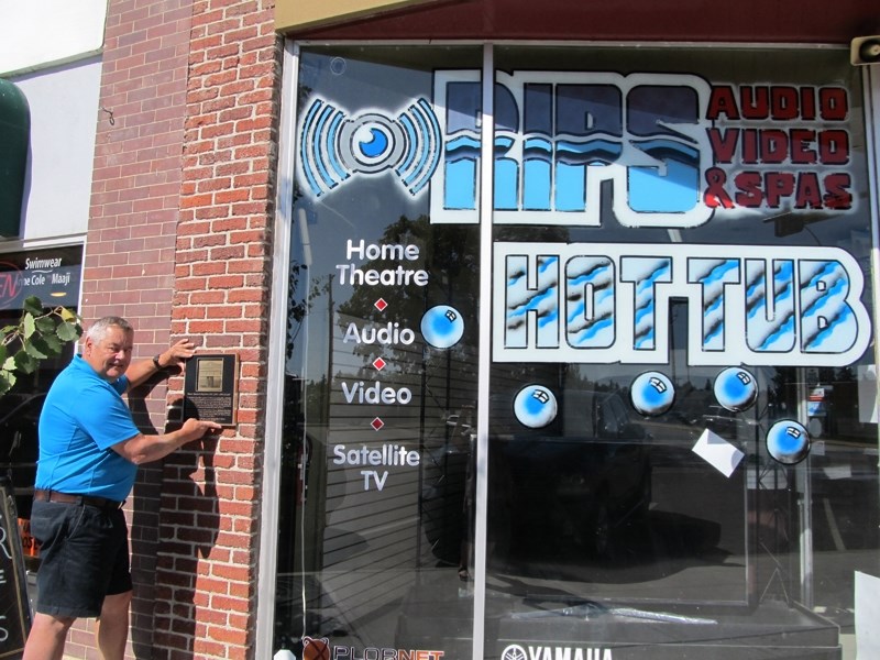 RIPS Audio Video &#038; Spas president Leon Durand displays a plaque that depicts the history of his building.