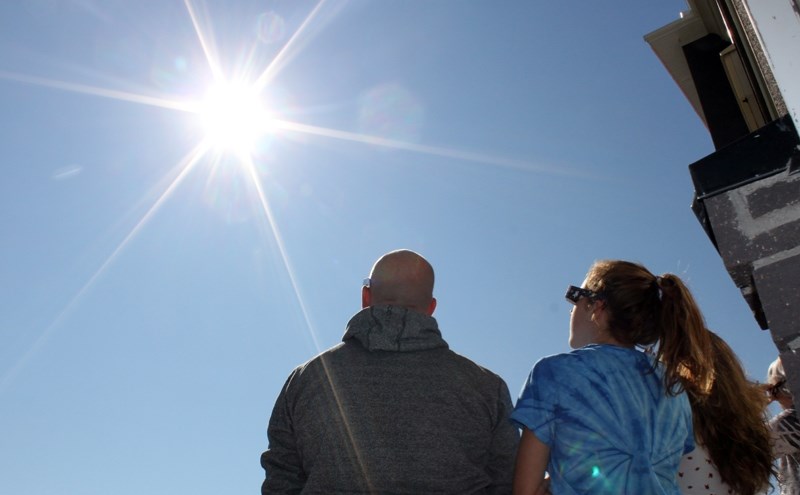 Bowden residents Gord Rose, left, and Teagan Rose, right, caught a glimpse of Monday&#8217;s solar eclipse, which was visible with 77 per cent coverage in Central Alberta.