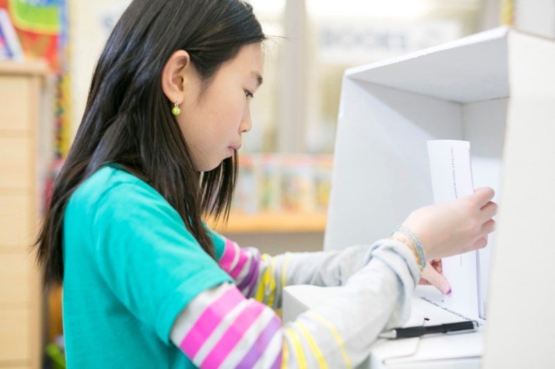 Grade 7 student Angelina Nguyen places her vote.