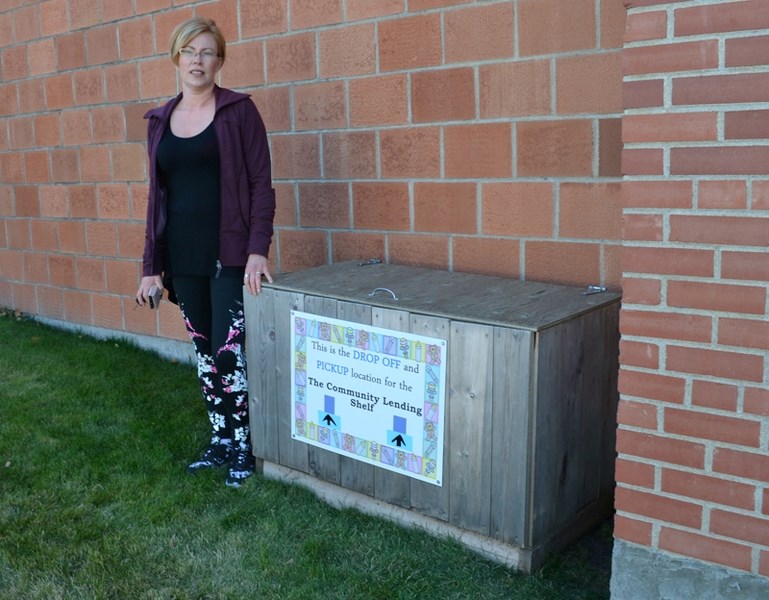 Lucinda Watkins points out a bin where people can drop off clothing outside the United Church.