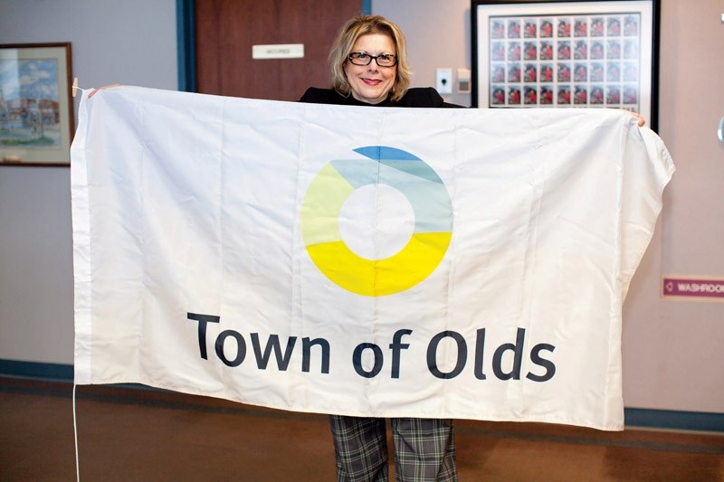 Mayor Judy Dahl with the new Town of Olds flag at the Olds town office last Tuesday.