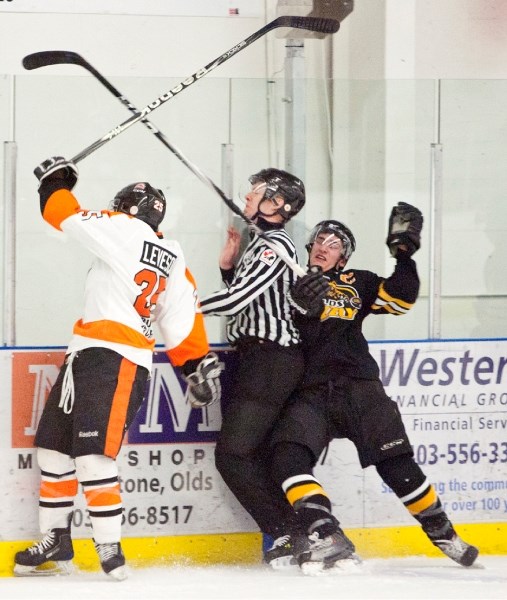 Olds Grizzlys player Clay Howe collides with a referee after being checked by a Drumheller Dragons player during their game at the Olds Sportsplex last Monday. The Dragons