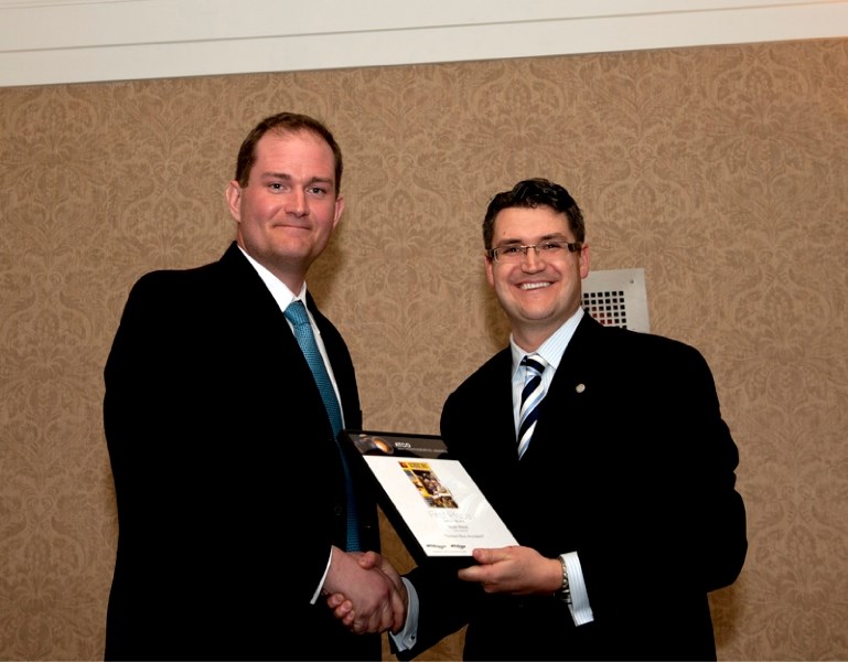 Albertan staff photographer Noel West (left) receives the first-place award for spot news at the annual ATCO photo awards in Calgary.
