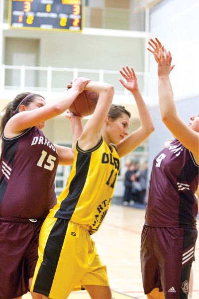 Olds Spartans player Amber Wright fights for possession of the ball with a Didsbury Dragons player during their game at the Ralph Klein Centre last Wednesday.