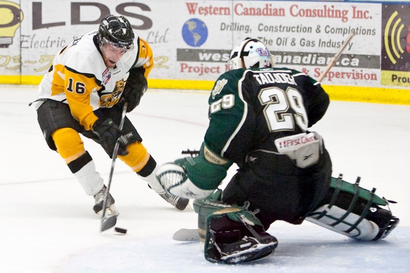 Olds Grizzlys player Scott Antonsen tries to get the puck past the Okotoks Oilers goaltender during the game last Friday at the Olds Sportsplex.