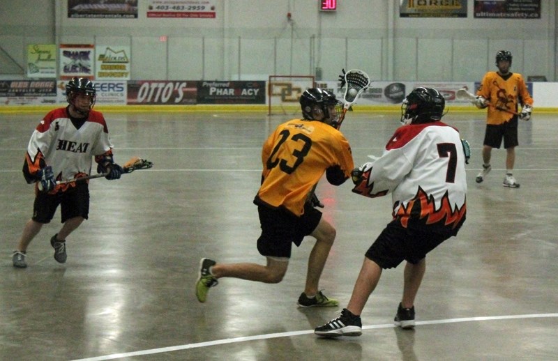Cale Brown of the Olds junior B Stingers tries to make his way past a High River Heat defender during a game at the Olds Sports Complex on June 2. The Heat won the game 10-6.
