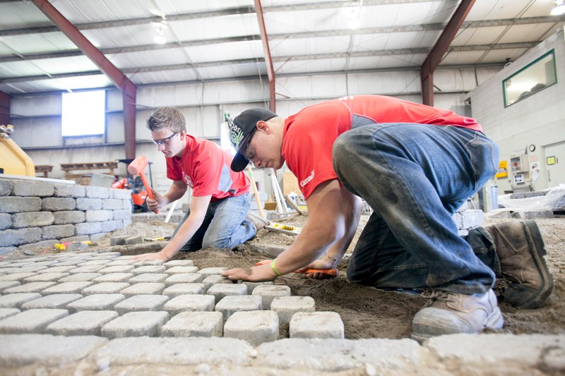 Jack Van Den Broek, left, and Justin Schipper practise laying out paving stones at the Landscape Construction Pavillion on the Olds College campus on June 4.