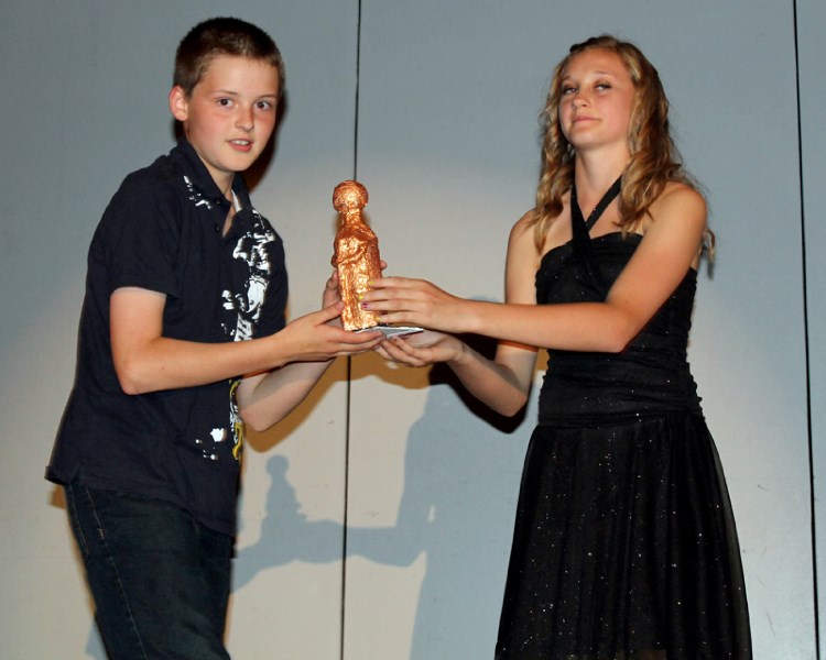 Connor Dixon accepts an award in the extraordinary male student in a supporting sports role during Ecole Deer Meadow School&#8217;s annual Academy Awards ceremony at the
