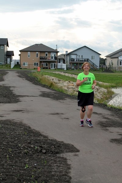 Marion Lonn of Calgary goes for an evening jog on July 28 on a new section of trail just north of Briegel Road.