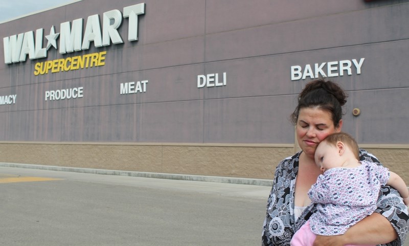 Tanya Planken holds her 10-month-old daughter Sarah outside of the Olds Wal-Mart. She said staff at the store told her she could no longer breastfeed her child in the