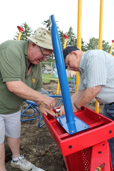 Hugh Bodmer (left), the Olds Kiwanis Club&#8217;s incoming president, and Harry Warne, a member of the club&#8217;s house committee work to assemble a transition station for