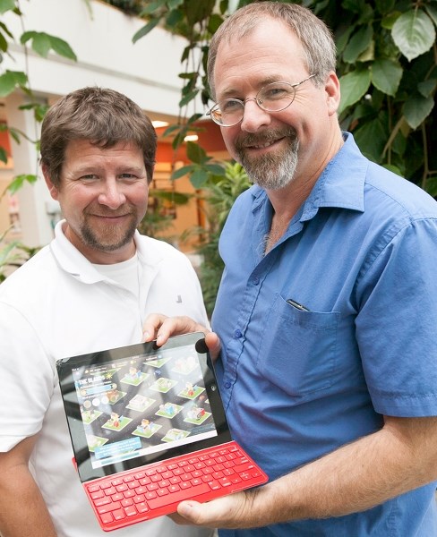 Olds College instructor Jason Pick, left, and Gordon Gilchrist, director of educational technology and curriculum show off one of the college&#8217;s new iPads on Aug. 23.