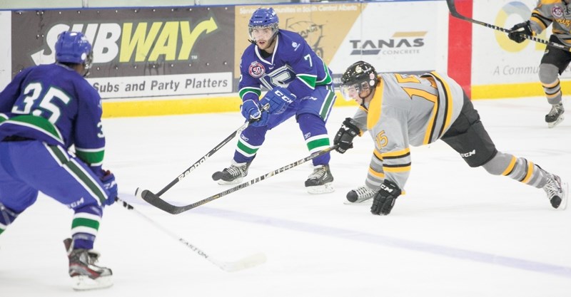 Olds Grizzlys team captain Spencer Dorowicz fights for possession of the puck during the Grizzlys game against the Calgary Canucks during the team&#8217;s first regular