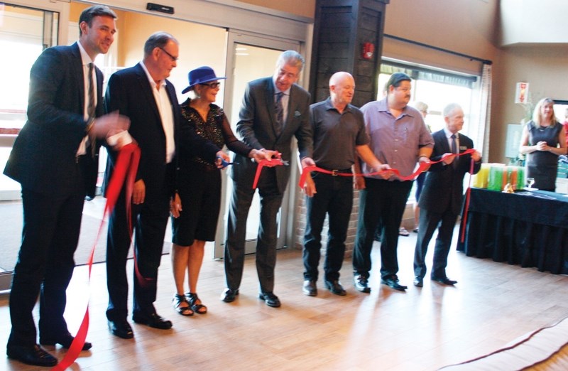 Tom Thompson, president of Olds College, and Judy Dahl, mayor of Olds, cut the ribbon during the grand opening of the Pomeroy Inn and Suites on Sept. 10. The pair are flanked 