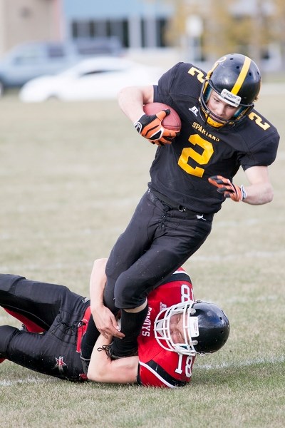 Olds High School Spartans player Dwayne Neustaeter gets tackled by Chestermere Cowboys player Mitchell Montpetit during their game at Normie Kwong Park on Oct. 1.
