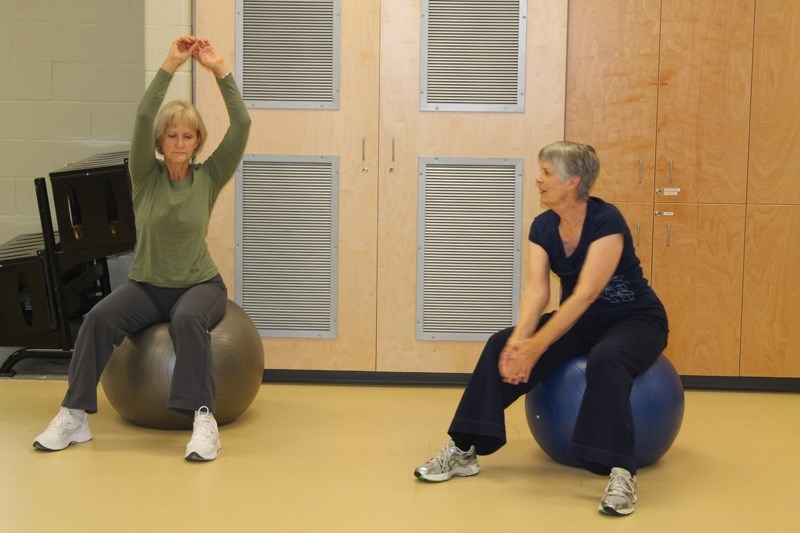 Clare MacMillan (left) and Catherine Ellis work out during a Senior Circuit and Social session at the Ralph Klein Centre on Oct. 10. The program offers seniors a chance to
