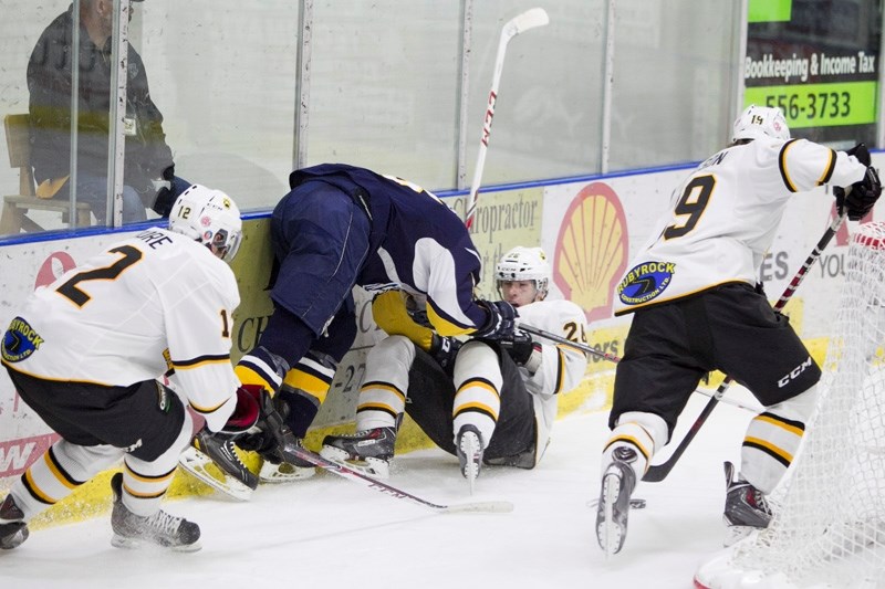 Olds Grizzlys player Cale Brown fights for possession of the puck with a Calgary Mustangs player during their game at the Olds Sports Complex on Oct. 8. The Mustangs won the