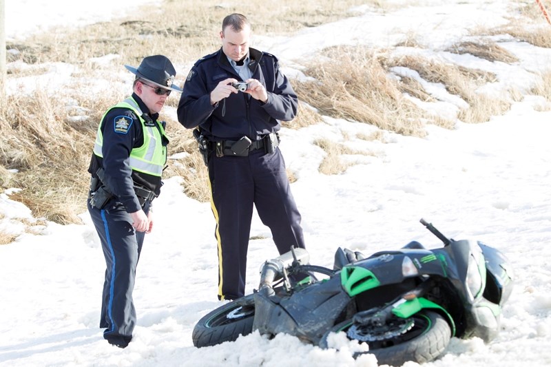Police speak with the suspect who was driving the motorcycle. Spencer Douglas Wilson, 24, of Calgary is charged with dangerous driving and 10 other charges.