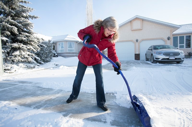 Glenna Schuler clears snow that came down during the Dec. 2 blizzard from her sister&#8217;s driveway on Shannon Drive on Dec. 6.