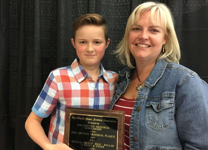 Evan LaGrange and his mom, Maggie, display one of his awards.