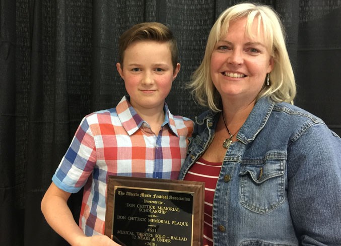 Evan LaGrange and his mom, Maggie, display one of his awards.