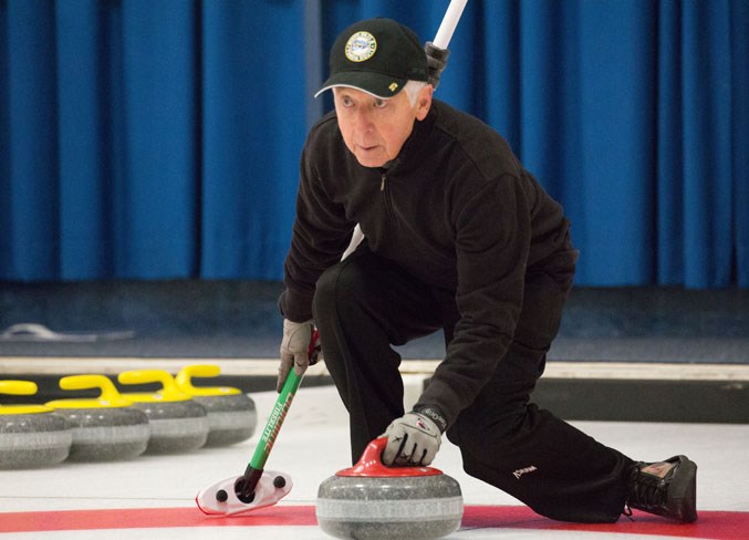 Grant Spence throws a rock at the curling club.