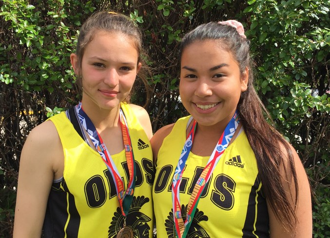 Abi Irving and Haylin Eling display their track and field medals.