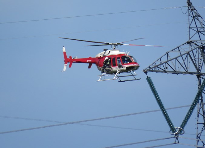 High tension power lines northwest of Olds are checked out via a helicopter.