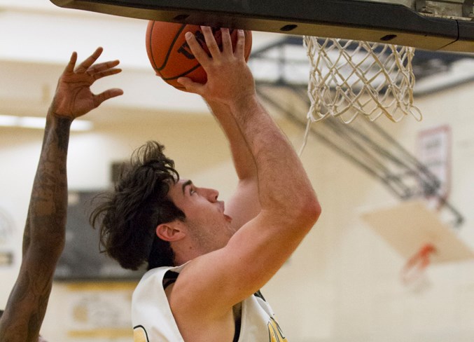 An Olds College Broncos player drives to the hoop during the game.