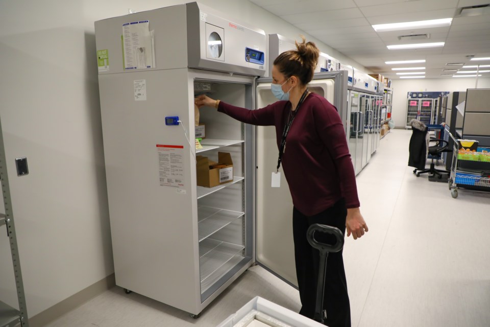 Pharmacy technician Erin Dysart opens a refrigeration unit at the York Region vaccine depot.
