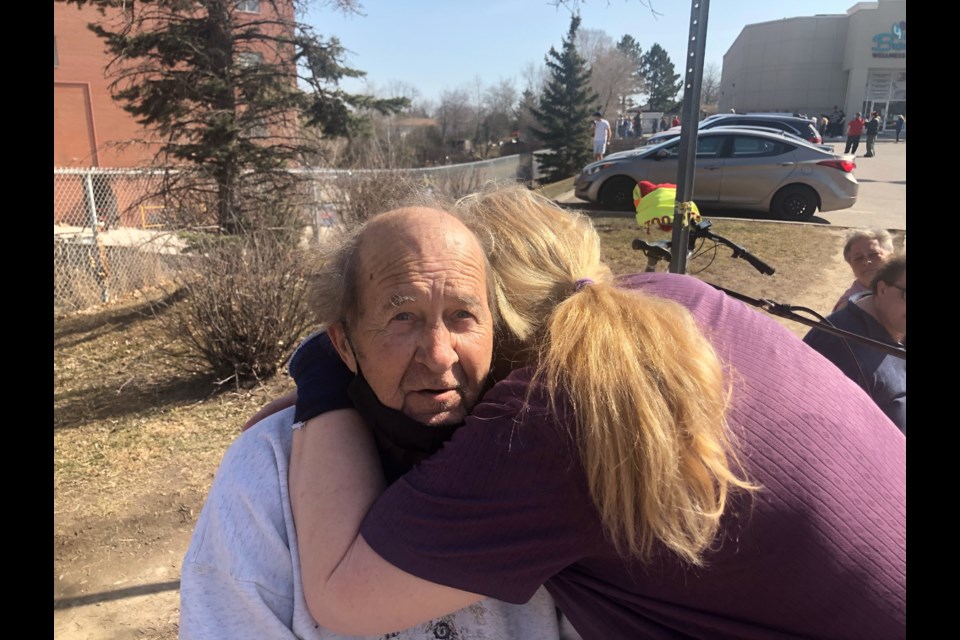 Terri-Lynn Brown hugs her father,  Tom Dunlop, after finding him outside the fire at his apartment building.
