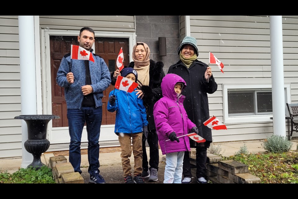 The Noori family hold flags given to them by sponsor Rex Taylor. 