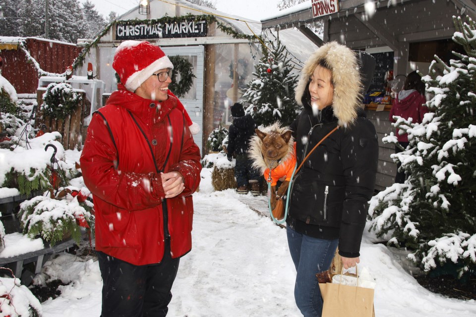 Ashley Niemi talks to Claire Bao, who just bought some treats for Chewie, at the Niemi Family Farm yesterday. Greg King for NewmarketToday