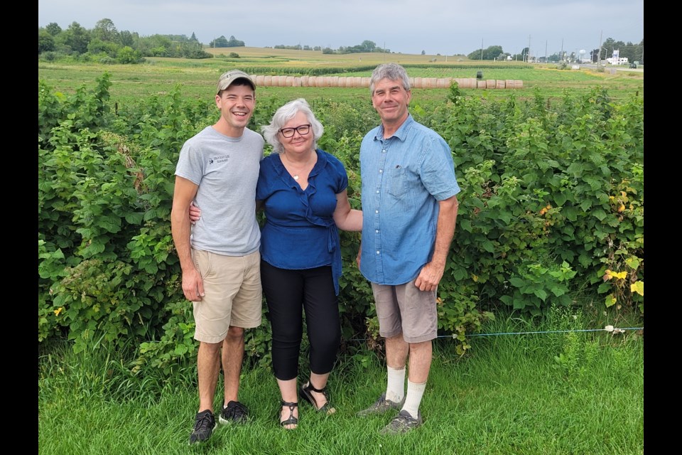 David, Mary-Anne, and Kevin Grose in front of their raspberry field at the farm.