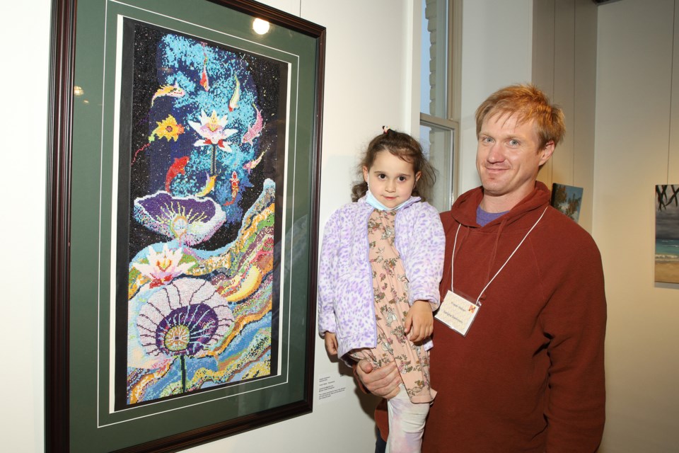 Artist Fraser Holben, with daughter Ivy, and his diamond dot piece entitled Sangha Swimmers at the Newmarket Juried Art Show opening gala last night. The show continues at the Old Town Hall until Sept. 25.  Greg King for NewmarketToday
