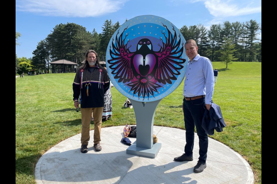 Indigenous artist Donald Chrétien and Mayor John Taylor unveil the new trail marker in Fairy Lake Park June 22.