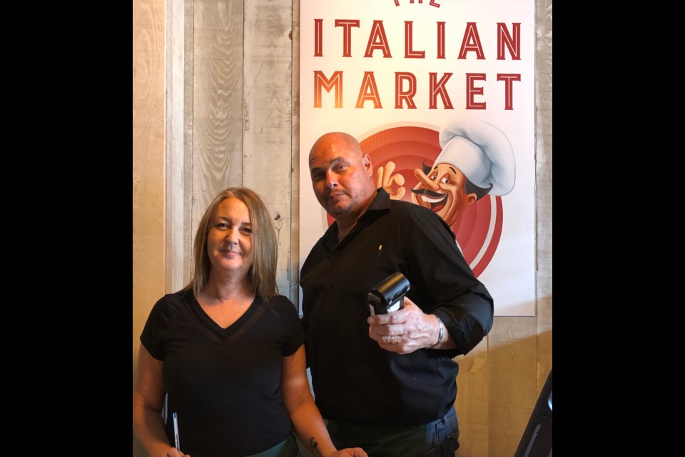 Servers Carmen Holloway and Jason FitzGerald welcome you to the Italian Market. Photography by Darlene Morrison