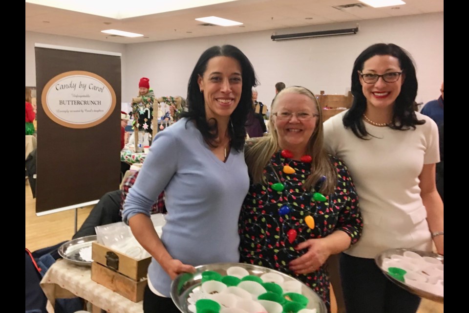 Shona and Shari MacDonald, of Candy by Carol (Handcrafted buttercrunch), shown here in 2018, say they love being part of the Grandparent Connection's Old Fashioned Christmas Craft Show, organized by Valerie Luttrell (centre). Supplied photo